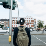 male pedestrain about to cross a busy intersection