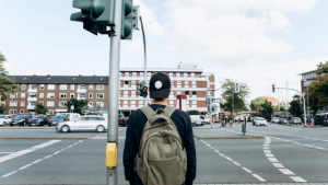male pedestrain about to cross a busy intersection