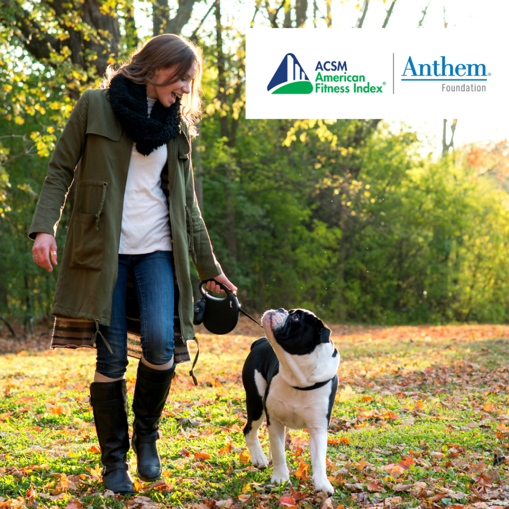 woman walking black and white dog in fall leaves