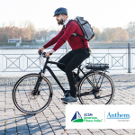 man in red sweater riding a bike with a backpack
