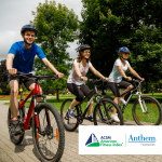three people riding bikes in a park