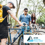 three people locking bikes to a bike rack